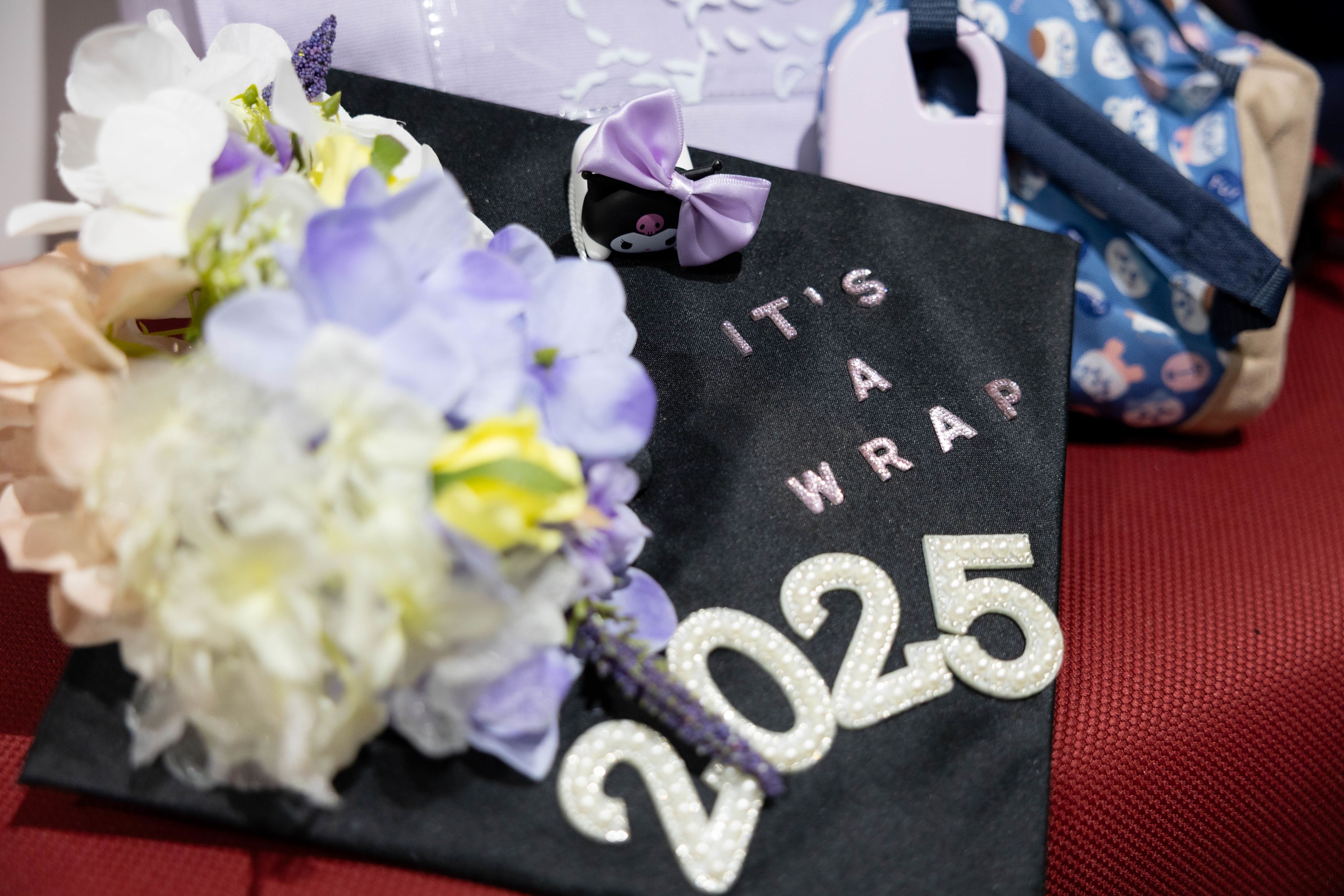 A graduate’s cap beautifully decorated with flowers and the message “It’s a wrap, 2025.”